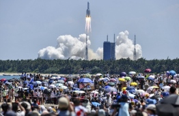 (FILES) In this file photo taken on July 24, 2022, onlookers watch the launch of a rocket transporting China’s second module for its Tiangong space station from the Wenchang spaceport in southern China. A Chinese booster rocket made an uncontrolled return to Earth on July 30, 2022, US Defense Department officials said, as they chided Beijing for not sharing information on the potentially hazardous object's descent. -- Photo: CNS / AFP