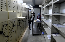 Conservators at the National Library of Tunisia, consult documents in the institution's archives in the capital Tunis, on January 26, 2022. - As part of a campaign to preserve the country's archives, the library staff have been working to digitise the documents. The collection includes some 16,000 titles printed in Tunisia, numbering hundreds of thousands of editions of newspapers and periodicals. (Photo by Fethi Belaid / AFP)