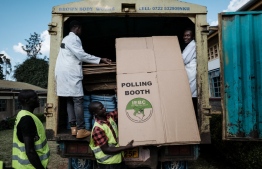 Staff members of the Independent Electoral and Boundaries Commission (IEBC) unload ballot boxes from a truck at the tallying center in Kilgoris, Kenya, on August 6, 2022, ahead of Kenya's general election. -- Photo: Yasuyoshi Chiba / AFP