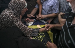 Relatives of Khaled Mansour, a top Islamic Jihad militant killed overnight in an Israeli air strike on Rafah in the southern Gaza Strip, react as they surround his body during his funeral in the same city, on August 7, 2022. - The death toll from violence in Gaza has risen to 29, including six children, the health ministry in the Palestinian enclave said today, correcting a previous statement. The health ministry also said that 253 people in Gaza had been wounded since the hostilities with Israel broke out on August 5. -- Photo: Said Khatib / AFP