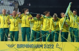 Gold medalists team Australia, including Australia's Tahlia McGrath (3L) wearing a face mask, stand on the podium during the medal ceremony for the women's Twenty20 Cricket on day ten of the Commonwealth Games at Edgbaston in Birmingham, central England, on August 7, 2022. -- Photo: Darren Staples / AFP
