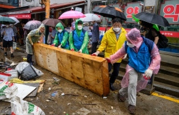 Workers clear debris at the historic Namseong Market in the Gangnam district of Seoul on August 9, 2022, after record-breaking rains caused severe flooding, with at least seven people dead and seven more missing, officials said. -- Photo: Anthony Wallace / AFP