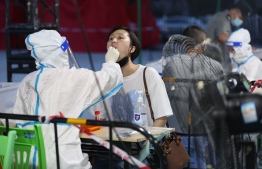 This photo taken on August 10, 2022 shows a health worker conducting a swab test on a resident for the Covid-19 coronavirus in Xiamen, in China's eastern Fujian province. -- Photo: AFP