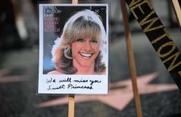 A photo is seen on the star of Australian singer and actress Olivia Newton-John on the Hollywood Walk of Fame in Hollywood, California, on August 8, 2022. - Australian singer Olivia Newton-John, who gained worldwide fame as high-school sweetheart Sandy in the hit musical movie "Grease," died on August 8, 2022, her family said. She was 73. The entertainer, whose career spanned more than five decades, devoted much of her time and celebrity to charities after being diagnosed with breast cancer in 1992. -- Photo: Robyn Beck / AFP