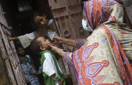 A health worker administers polio drops to a child during a polio vaccination campaign in Karachi on August 15, 2022. -- Photo: Rizwan Tabassum / AFP