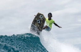 Young rising local surf prodigy Mohamed Inaan Abdul Hannan breaks point over a wave before tubing-- Photo: Maldives Surf Photographer