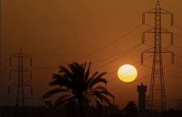 (FILES) In this file photo the sun sets behind high voltage transmission towers (electricity pylons) in Egypt's Qalyubia governorate of the Nile Delta, on June 26, 2022. Depleted foreign currency reserves are casting a shadow on Egyptian streets, with the government moving to dim lights to free up energy for export. More natural gas exports means more hard currency, a dire need as experts say a new loan from the International Monetary Fund (IMF) – and an adjacent currency liberalisation – is inevitable. -- Photo: Khaled Desouki / AFP