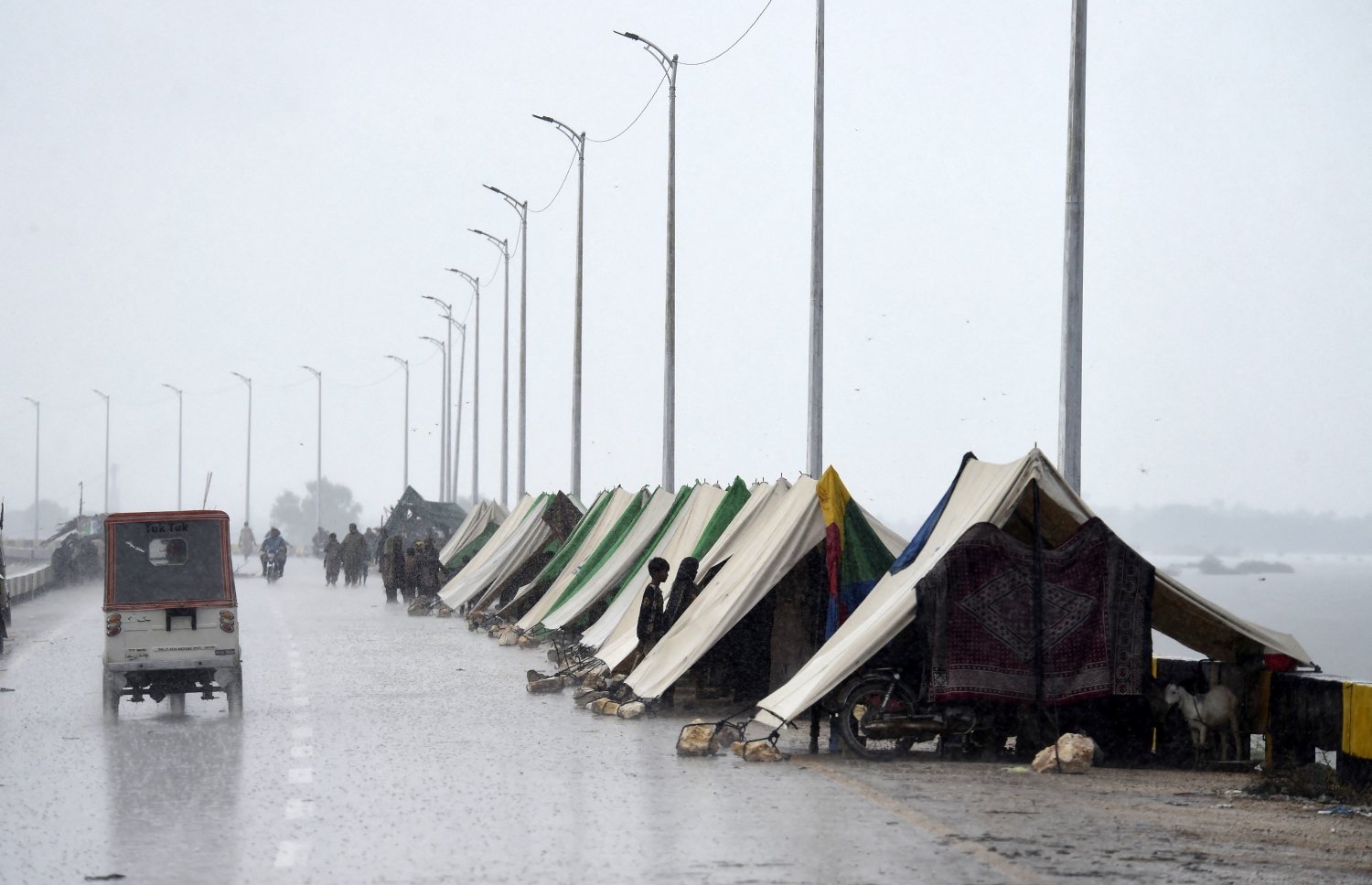 ޕާކިސްތާން: އޮގަސްޓް 27، 2022: މޫސުން ގޯސްވެ ޕާކިސްތާންގައި އާދަޔާ ހިލާފަށް ފެންބޮޑުވެފައި: މި ހާދިސާގައި ގެއްލުން ލިބުނު ގެތަކުގައި ދިރިއުޅޭ މީހުން ވަގުތީ ޓެންޓުތަކުގައި، މިހާތަނަށް 1000 އަށް ވުރެ ގިނަ މީހުން ވަނީ މަރުވެފައި.-- ފޮޓޯ: އޭއެފްޕީ