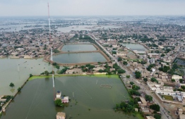 This aerial view shows a flooded residential area in Dera Allah Yar town after heavy monsoon rains in Jaffarabad district, Balochistan province on August 30, 2022. - Aid efforts ramped up across flooded Pakistan on August 30 to help tens of millions of people affected by relentless monsoon rains that have submerged a third of the country and claimed more than 1,100 lives. (Photo by Fida Hussain/ AFP)