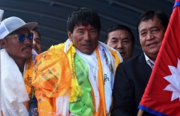 In this file photo taken on August 20, 2022, Nepali mountaineer Sanu Sherpa (C) is welcomed upon arriving at Tribhuvan airport after becoming the first climber to summit all the world's 14 peaks above 8000 meters (26,247 ft) for the second time, in Kathmandu. - Summiting the world's fourteen 8,000-metre mountains is the ultimate bucket list for ambitious climbers, a feat managed by fewer than 50 people in history, and Sanu Sherpa is the first to do it twice. (Photo by Prakash MATHEMA / AFP) /