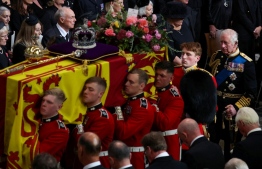 The coffin of Britain's Queen Elizabeth II is carried out of the Westminster Abbey followed by Britain's King Charles III (R) in London on September 19, 2022, during the State Funeral Service. (Photo by PHIL NOBLE / POOL / AFP)