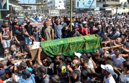 Mourners march with the body of one of the victims who drowned in the shipwreck of a migrant boat that sank off the Syrian coast, during his funeral after the return of his body in Lebanon's northern port city of Tripoli on September 24, 2022. - At least 77 migrants drowned when a boat they boarded in Lebanon sank off Syria's coast, in one of the deadliest such shipwrecks in the eastern Mediterranean. Lebanon, which since 2019 has been mired in a financial crisis branded by the World Bank as one of the worst in modern times, has become a launchpad for illegal migration, with its own citizens joining Syrian and Palestinian refugees clamouring to leave their homeland. Around 150 people, mostly Lebanese and Syrians, were on board the small boat that went down Thursday off the Syrian city of Tartus. (Photo by Fathi AL-MASRI / AFP)