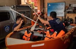 Members of the Disaster Risk Reduction and Management Office prepare rubber boats and life vests ahead of Super Typhoon Noru making landfall, at their headquarters in Quezon City, suburban Manila on September 25, 2022. (Photo by Kevin Tristan ESPIRITU / AFP)