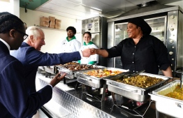 (FILES) In this file photo taken on May 4, 2022 Britain's Prince Charles, Prince of Wales meets with Maureen at her food van enterprise  during a visit at the Dexters Adventure Playground in Brixton, south London,  to meet members and young people supported by the British charity BIGKID foundation. - Queen Elizabeth II's death earlier this month prompted a flood of tributes -- but not from everyone. In Britain's black community, many asked: what had she ever done for us? (Photo by Aaron Chown / POOL / AFP)