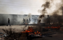 Palestinian protesters burn tyres near Al-Jalazun refugee camp, near the Israeli settlement of Beit El in the occupied West Bank, on October 3, 2022, after Israeli forces killed two Palestinians nearby at dawn. -- Photo: Abbas Momani / AFP
