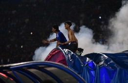This picture taken on October 1, 2022 shows people reacting as tear gas is let off by police after a football match between Arema FC and Persebaya at the Kanjuruhan stadium in Malang, East Java. - Anger against police mounted in Indonesia on October 3 after at least 125 people were killed in one of the deadliest disasters in the history of football, when officers fired tear gas in a packed stadium, triggering a stampede. -- Photo: AFP
