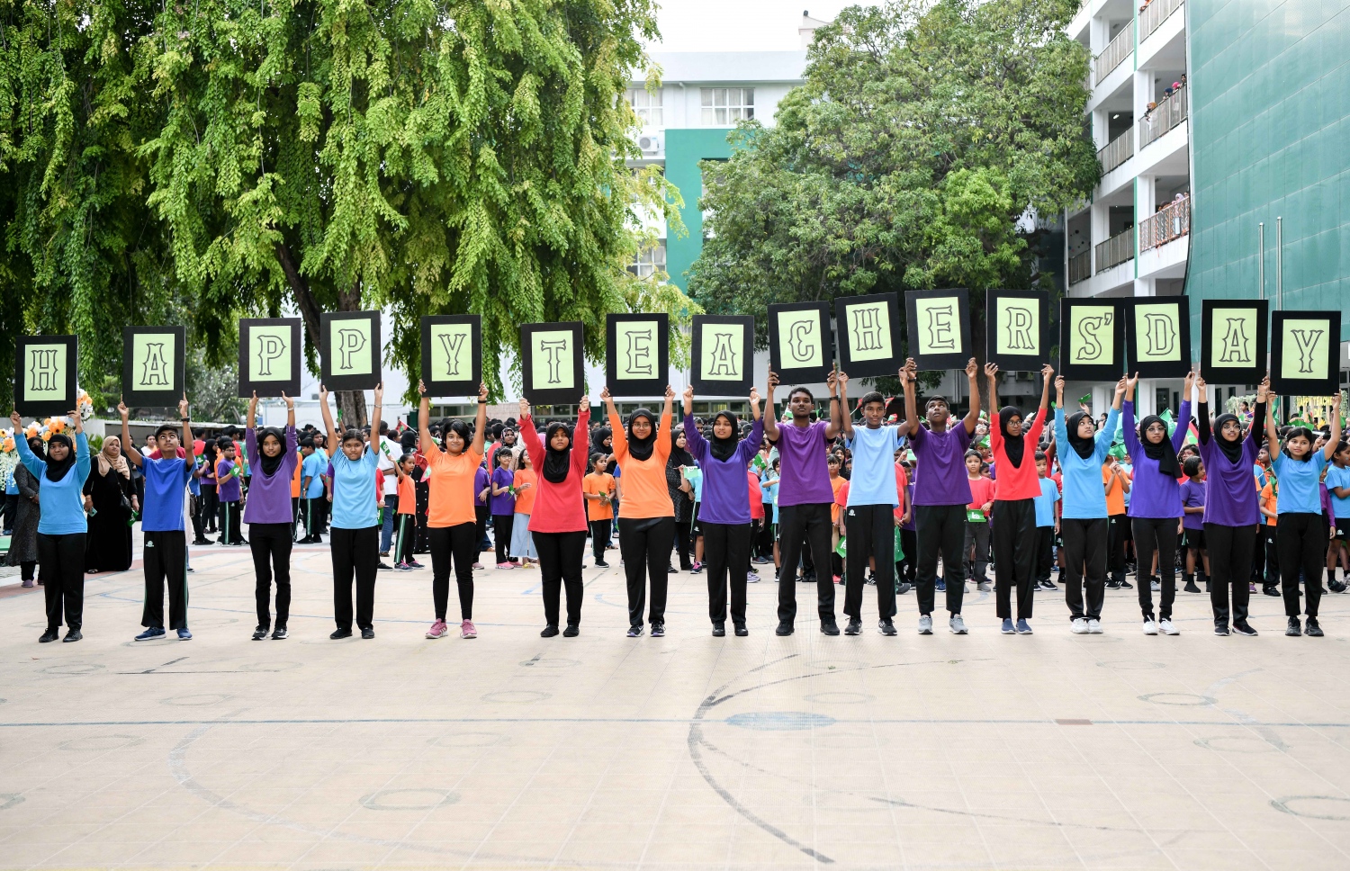 ޓީޗަރުންގެ ދުވަސް ފާހަގަކުރަން އަމީނިއްޔާ ސްކޫލުގައި މިއަދު ބޭއްވި ހާއްސަ ރަސްމިއްޔާތުގައި، ދުވަހުގެ ތަހުނިޔާ ކިޔައި ދަރިވަރުން ފޮޓޯއަކަށް ހުއްޓިލައިގެން.-- ފޮޓޯ: ނިޝާން އަލީ/ މިހާރު