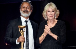 Sri Lankan writer Shehan Karunatilaka (L) poses next to Britain's Camilla, Queen Consort (R) after winning the British Booker Prize for his novel "The Seven Moons of Maali Almeida", during the Booker Prize for Fiction 2022 awards ceremony, in London, on October 17, 2022. -- Photo: Toby Melville / POOL / AFP