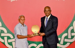 President Ibrahim Mohamed Solih (L) presents National Award of Honour to a receiptient on October 20 -- Photo: President's Office