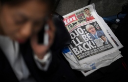 A copy of The Sun newspaper featuring former prime minister Boris Johnson lies on the floor outside 10 Downing Street in central London on October 21, 2022. - Contenders bidding to succeed Prime Minister Liz Truss canvassed for support with her predecessor Boris Johnson reportedly considering a sensational comeback, while opposition parties demanded an early general election to end months of political chaos. -- Photo: Daniel Leal / AFP