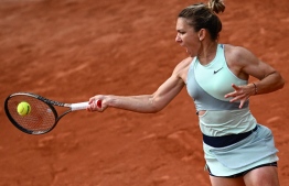 (FILES) In this file photo taken on May 26, 2022 Romania's Simona Halep returns to China's Qinwen Zheng during their women's singles match on day five of the Roland-Garros Open tennis tournament at the Court Simonne-Mathieu in Paris. - Former world number one Simona Halep has been provisionally suspended for doping after testing positive for a banned substance, the International Tennis Integrity Agency (ITIA) said on October 21, 2022. -- Photo by Anne-Christine Poujoulat / AFP