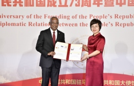 Chinese Ambassador to Maldives Wang Lixin (L) presents President Ibrahim Mohamed Solih with a Golden Jubilee memento during the ceremony held to celebrate 50 years of diplomatic relations between China and Maldives on October 22, 2022 -- Photo: Nishan Ali / Mihaaru
