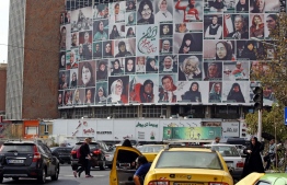 Iranians drive past a huge billboard showing a montage of pictures titled “the women of my land, Iran” featuring Iranian women who are all observing the hijab, on Valiasr Square in Tehran, on October 13, 2022 --Photo: STR / AFP
