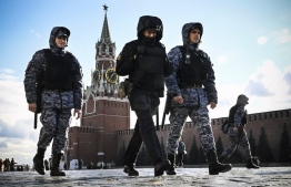 Police and the Russian National Guard (Rosgvardia) servicemen patrol Red Square in front of the Spasskaya tower of the Kremlin in Moscow on October 24, 2022, as part of security reinforcement measures. (Photo by Alexander NEMENOV / AFP)