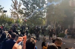 This image grab from a UGC video posted on October 30, 2022, reportedly shows protesters avoiding projectiles during clashes at Iran's University of North Tehran. (Photo by UGC / AFP)