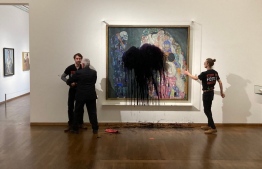 This handout picture released on November 15, 2022 by the "Last Generation" shows a climate activist of the "Last Generation" group being overpowerd whereas another one has glued himself to the painting "Death and Life" by Austrian artist Gustav Klimt after pouring black liquid over the art work at the Leopold Museum in Vienna, Austria. A spokesman of the museum said that restorers were working to determine whether the painting protected by glass has been damaged. Admission to the Leopold Museum was free on Tuesday, November 15, as part of a day sponsored by the Austrian oil and gas group OMV. Photo by handout: Letzte Generation Österreich / AFP