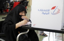 An elderly Bahraini woman prepares her ballot at a polling station in the city of Jidhafs, about 3km west of the capital Manama, during parliamentary elections, on November 12, 2022. - More than 330 candidates, including a record 73 women, are competing to join the 40-seat council of representatives, the lower house of parliament that advises King Hamad bin Isa Al-Khalifa, who has ruled since his father died in March 1999. (Photo by AFP)