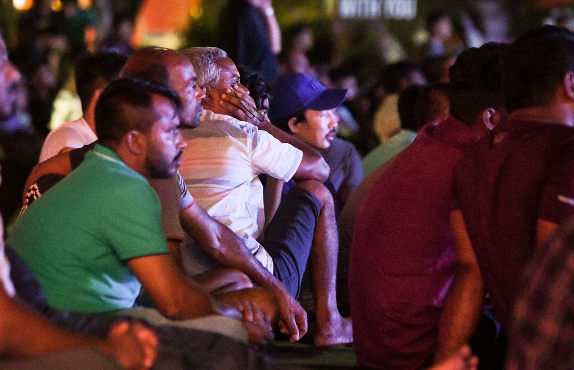 ވޯލްޑް ކަޕްގެ ފުރަތަމަ މެޗުގައި އިކުއެޑޯއާ އާއި ގަތަރުގެ ކުޅުން، ސޯޝަލް ސެންޓަރުގެ ބޮޑު ސްކްރީނުން ބަޔަކު ބަލަނީ: މާލޭގެ އެކި ސަރަހައްދުތަކުގައި ވަނީ ވޯލްޑް ކަޕްގެ މެޗުތައް ބަލަން ސްކްރީންތައް ބަހައްޓާފައި.---ފޮޓޯ: ފަޔާޒު މޫސާ| މިހާރު