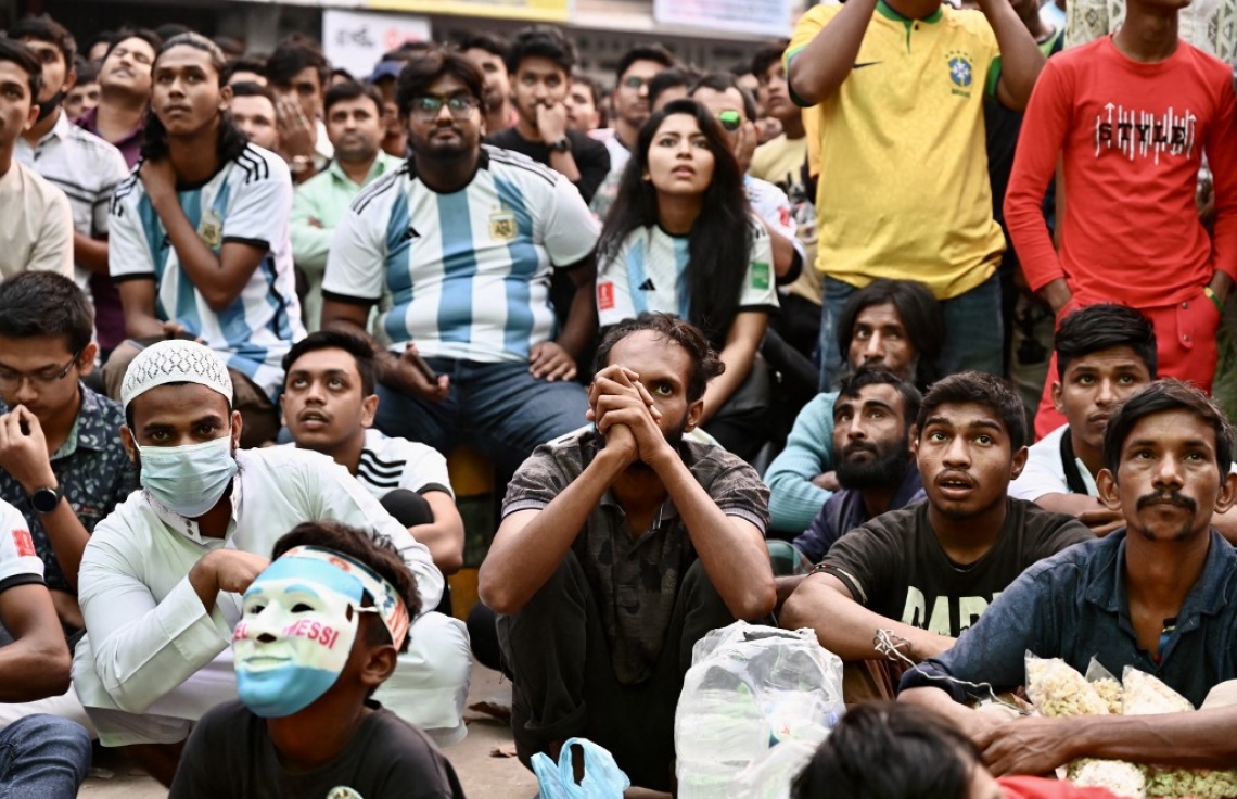 ވޯލްޑް ކަޕުގައި ސައޫދީ އަރަބިއްޔާ އާއި އާޖެންޓީނާ ބައްދަލުކުރި މެޗު ބަންގްލަދޭޝްގެ ރައްޔިތުން އެ ގައުމުގެ ވެރިރަށް ޑާކާގައި ބޮޑު ސްކްރީނުން ބަލަނީ: މި މެޗުން ސައޫދީ ވަނީ 2-1 އިން މޮޅުވެ މުޅި ދުނިޔެ ހައިރާންކޮށްލާފައި. --ފޮޓޯ: އޭއެފްޕީ