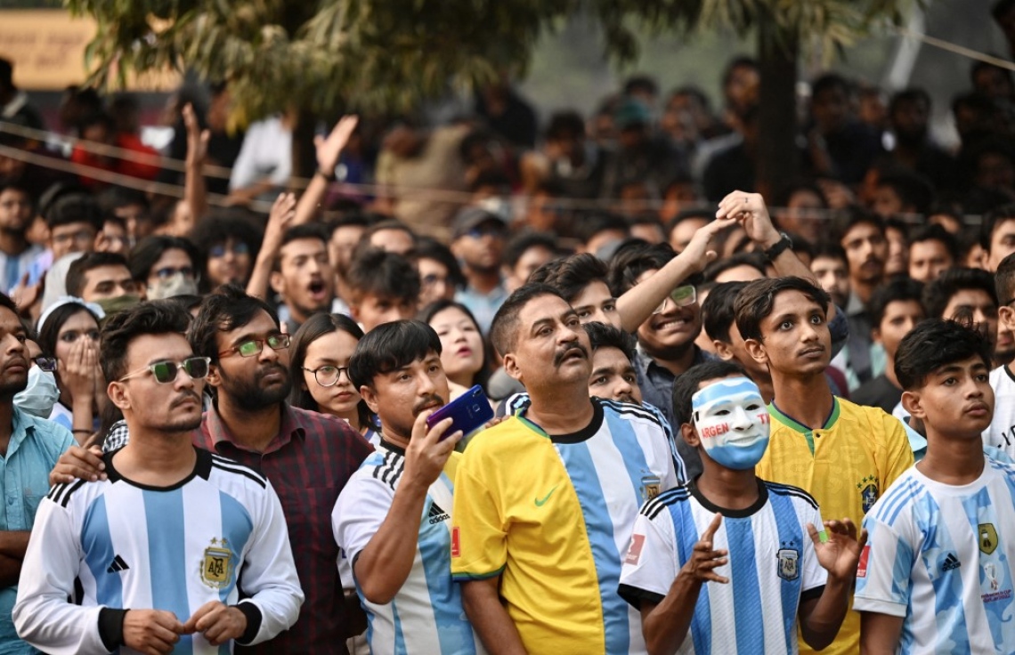 ވޯލްޑް ކަޕުގައި ސައޫދީ އަރަބިއްޔާ އާއި އާޖެންޓީނާ ބައްދަލުކުރި މެޗު ބަންގްލަދޭޝްގެ ރައްޔިތުން އެ ގައުމުގެ ވެރިރަށް ޑާކާގައި ބޮޑު ސްކްރީނުން ބަލަނީ: މި މެޗުން ސައޫދީ ވަނީ 2-1 އިން މޮޅުވެ މުޅި ދުނިޔެ ހައިރާންކޮށްލާފައި. --ފޮޓޯ: އޭއެފްޕީ