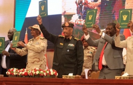 Sudan's Army chief Abdel Fattah al-Burhan (C) and paramilitary commander Mohamed Hamdan Dagalo (2nd L) lift documents alongside civilian leaders following the signature of an initial deal aimed at ending a deep crisis caused by last year's military coup, in the capital Khartoum on December 5, 2022. - The past year has seen near-weekly protests and a crackdown that pro-democracy medics say has killed at least 121, a spiralling economic crisis exacerbated by donors slashing funding, and a resurgence of ethnic violence in several remote regions. Divisions among civilian groups have deepened since the coup, with some urging a deal with the military while others insist on "no partnership, no negotiation". -- Photo: Ashraf Shazly / AFP