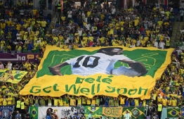 Brazil supporters display a banner depicting Brazilian football legend Pele and reading "Pele, get well soon" during the Qatar 2022 World Cup round of 16 football match between Brazil and South Korea at Stadium 974 in Doha on December 5, 2022. (Photo by Manan Vatsayayana / AFP)