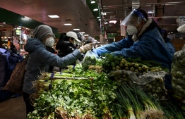 A woman buys vegetables at a market in Beijing on December 8, 2022. -- Photo: Noel Celis/ AFP