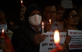 People hold candles and placards during a vigil on the tenth anniversary of the heinous gang rape of a young woman, in New Delhi on December 16, 2022. - Ten years ago the brutal gang rape and murder of a young woman on a Delhi bus horrified the world and shone a spotlight on high rates of sexual violence in India. But a decade after the assault many women are still scared to travel at night in India's capital, a sprawling metropolis of 20 million people. -- Photo: Money Sharma / AFP