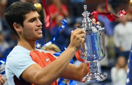 (FILES) In this file photo taken on September 12, 2022 Spain's Carlos Alcaraz celebrates with the trophy after winning against Norway's Casper Ruud during their 2022 US Open Tennis tournament men's singles final match at the USTA Billie Jean King National Tennis Center in New York. - With the retirements of Roger Federer, Serena Williams and Ashleigh Barty, tennis has experienced a huge breath of fresh air in 2022, quickly filled by Carlos Alcaraz and Iga Swiatek, but beware: Rafael Nadal is not quite gone and Novak Djokovic is still hungry. -- Photo: Angela Weiss / AFP