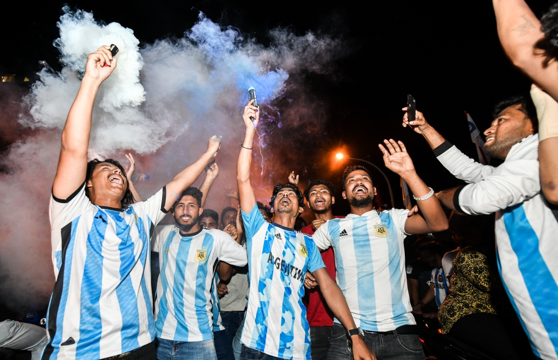 އާޖެންޓީނާ އިން ވޯލްޑް ކަޕް ކާމިޔާބުކުރުމާ ގުޅިގެން މާލޭގައި ތިބޭ އެ ޓީމުގެ ސަޕޯޓަރުން ސްމޯކް އަރުވައި އުފާފާޅުކުރަނީ.--- ފޮޓޯ: ފަޔާޒު މޫސާ | މިހާރު