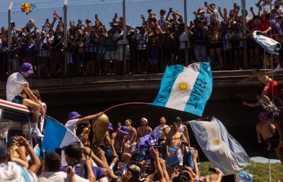 ވޯލްޑް ކަޕުގެ ތަށި ހިފައިގެން އާޖެންޓީނާ ކުޅުންތެރިން އެ ގައުމުގެ ވެރިރަށް ބީނޯސް އޭރީޒްގައި ބޭއްވި ބަސް ޕެރޭޑުގައި އާންމުން ބައިވެރިވެ އުފާފާޅުކުރަނީ: މިއީ އާޖެންޓީނާ ވޯލްޑް ކަޕް ތަށި އުފުލާލި ތިންވަނަ ފަހަރު.-- ފޮޓޯ: އޭއެފްޕީ