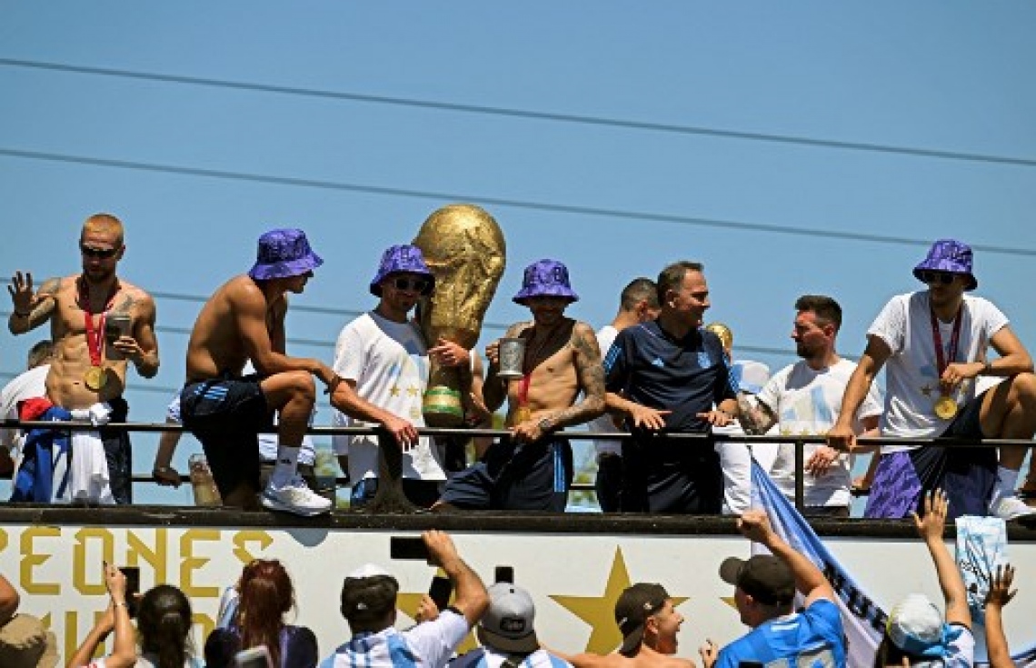 ވޯލްޑް ކަޕުގެ ތަށި ހިފައިގެން އާޖެންޓީނާ ކުޅުންތެރިން އެ ގައުމުގެ ވެރިރަށް ބީނޯސް އޭރީޒްގައި ބޭއްވި ބަސް ޕެރޭޑުގައި އާންމުން ބައިވެރިވެ އުފާފާޅުކުރަނީ: މިއީ އާޖެންޓީނާ ވޯލްޑް ކަޕް ތަށި އުފުލާލި ތިންވަނަ ފަހަރު.-- ފޮޓޯ: އޭއެފްޕީ