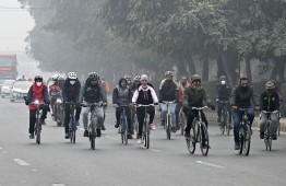 Cyclists take part in a pollution and smog awareness campaign as they ride along a street towards the Wagah border, in Lahore on December 25, 2022. -- Photo: Arif Ali / AFP