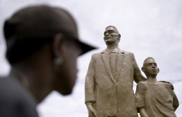 A man looks at statues of Pele (R) and his father Dondinho (L), in his hometown Tres Coracoes, state of Minas Gerais, Brazil, on December 30, 2022. - Brazil started three days of national mourning on Friday for football legend Pele, the three-time World Cup winner widely regarded as the greatest player of all time, who has died at the age of 82. -- Photo: Douglas Magno / AFP