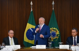 Brazil's President Luiz Inacio Lula da Silva (C) speaks beside his Vice President and Minister of Industry and Trade Geraldo Alckmin (L) and Chief of Staff Rui Costa (R) during his government's first cabinet meeting at the Planalto Palace in Brasilia on December 6, 2023. (Photo by EVARISTO SA / AFP)