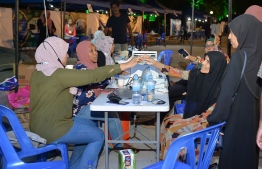 People making donations to the fund during the city council's event to raise money to repair mosques in the Artificial Beach area--
