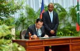 Cambodian Prime Minister Hun Sen signs the guest signature book at the President's Office, President Ibrahim Mohamed Solih waits beside him -- Photo: President's Office