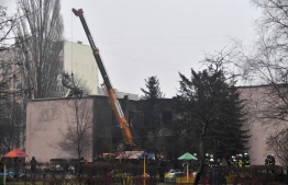 A part of a helicopter that crashed near a kindergarten is removed in Brovary, outside the capital Kyiv, on January 18, 2023, amid the Russian invasion of Ukraine. Eighteen people, including Ukraine´s interior minister and three children, were killed in a helicopter crash near a kindergarten outside Kyiv on January 18, 2023. -- Photo: Sergei Supinsky / AFP