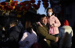 People visit a hutong (alley) in Beijing on January 31, 2023. -- Photo by Wang Zhao / AFP