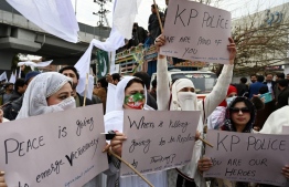 Supporters of former Pakistan's prime minister Imran Khan hold placards during a peace rally following a mosque suicide blast inside police headquarters, in Peshawar on February 3, 2023. - The suicide bomber who killed more than 80 police officers at a mosque inside a sensitive compound earlier this week entered wearing a uniform and helmet, a provincial police chief said on February 2. -- Photo: Abdul Majeed / AFP